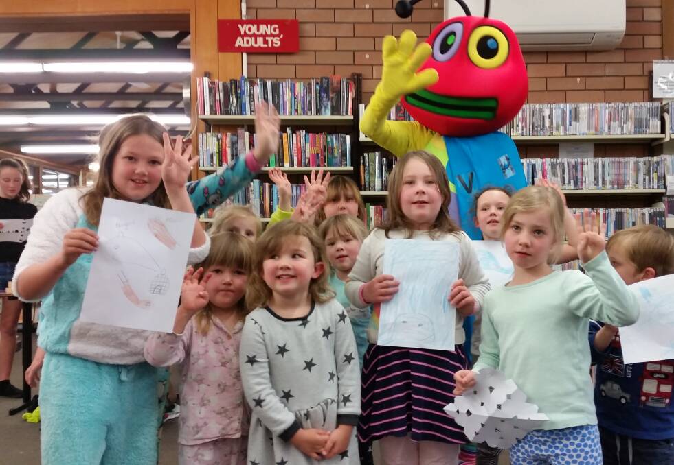 GETTING THE READING BUG: Happy faces at the library with Doug the Reading Bug for his school holiday pajama party.