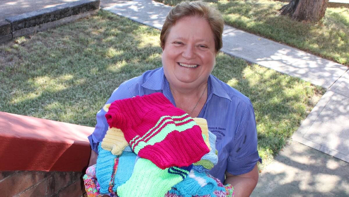 GENEROUS: Lurline Trustum from Dungog Neighbourcare with a selection of the brightly coloured knitted garments bound for overseas. 