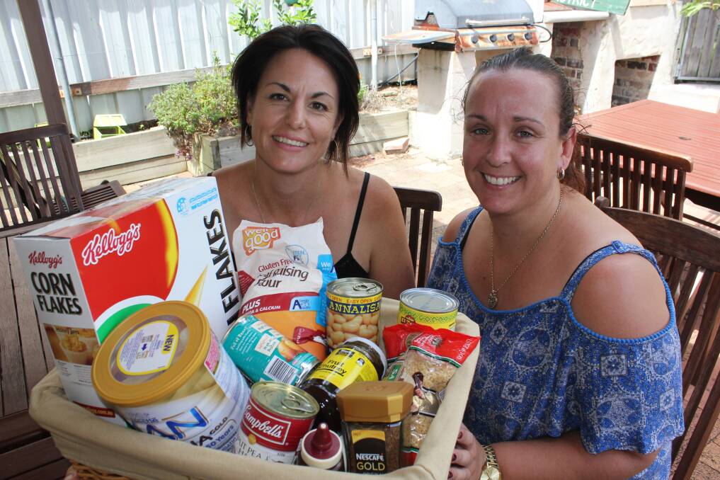 Groceries: Sarah U'Brien and Karyn Marsh from the Dungog Shire Community Centre and a basket of pantry items.