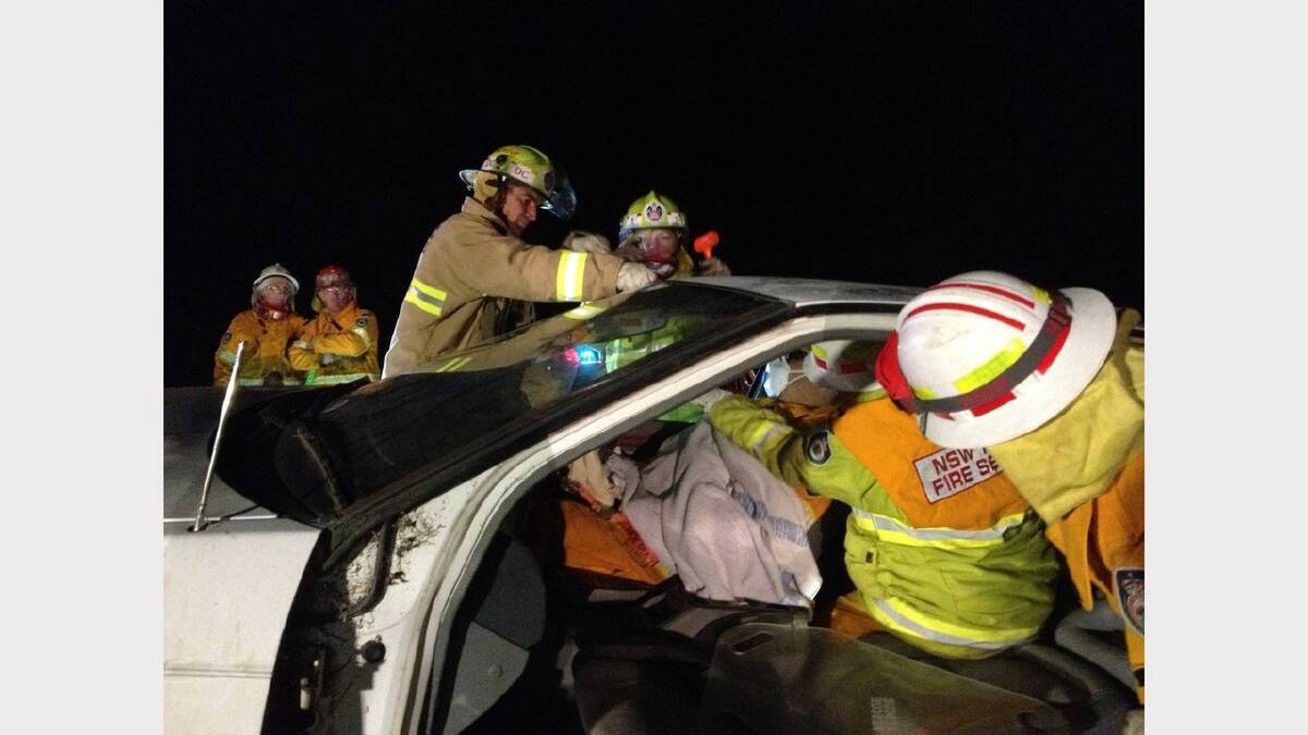 Deputy Captain Andrew Viner prepares to remove the front windscreen whilst RFS Fire Fighter Matt Faulkner plays the role of patient