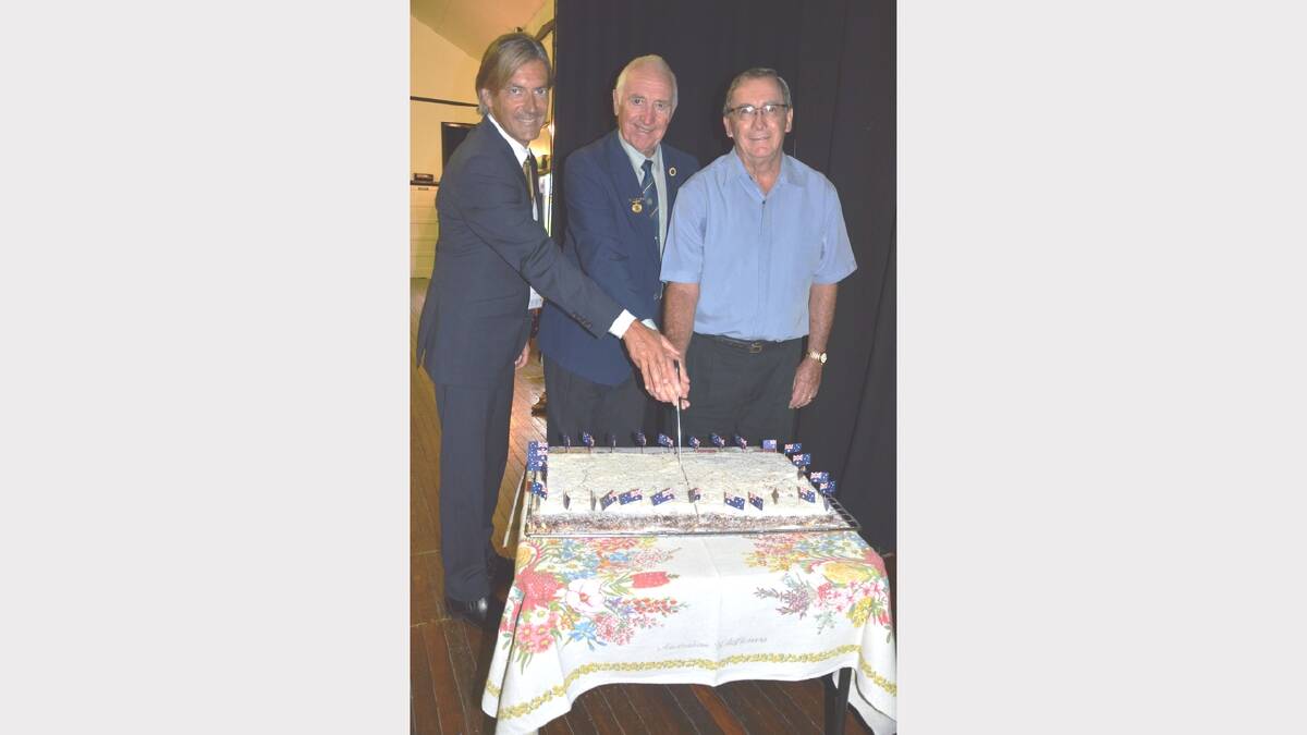 Cutting the Australia Day cake was ambassador George Ellis and award recipients Ken Russell and John Copus.