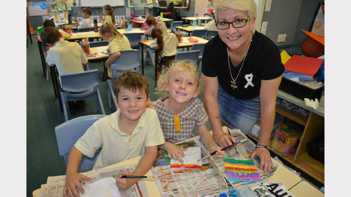 Teacher Robyn Norris with students George Black and Isla Briggs making the panels for a quilt