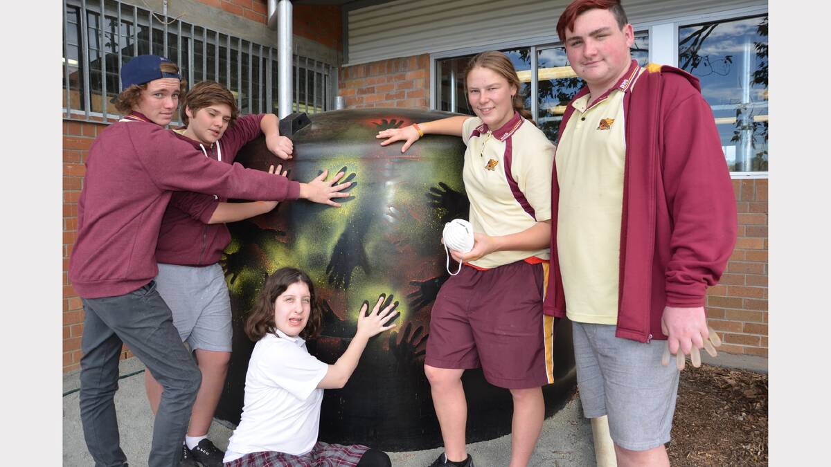 Dungog High School students Will Rooke, Sam Russell, Sammy Black, Rachael Somerville and Ronnie Piper leave their mark on the new water tank for the bush tucker garden.