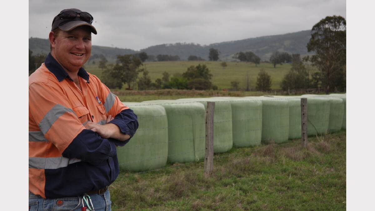 Matt Kealy with some of the round bales of hay donated to the farmers at Coonabarabran.