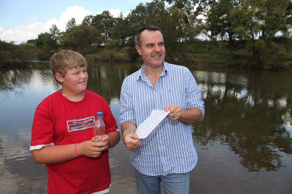 Message-in-a-bottle sender Cameron Hipwell, 13, and the finder, James Madigan, by the river that carried it. Picture: Phil Hearne