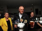 Scott Morrison poured beers for two lucky punters at the Edgeworth Tavern on Wednesday night. Picture: Peter Lorimer