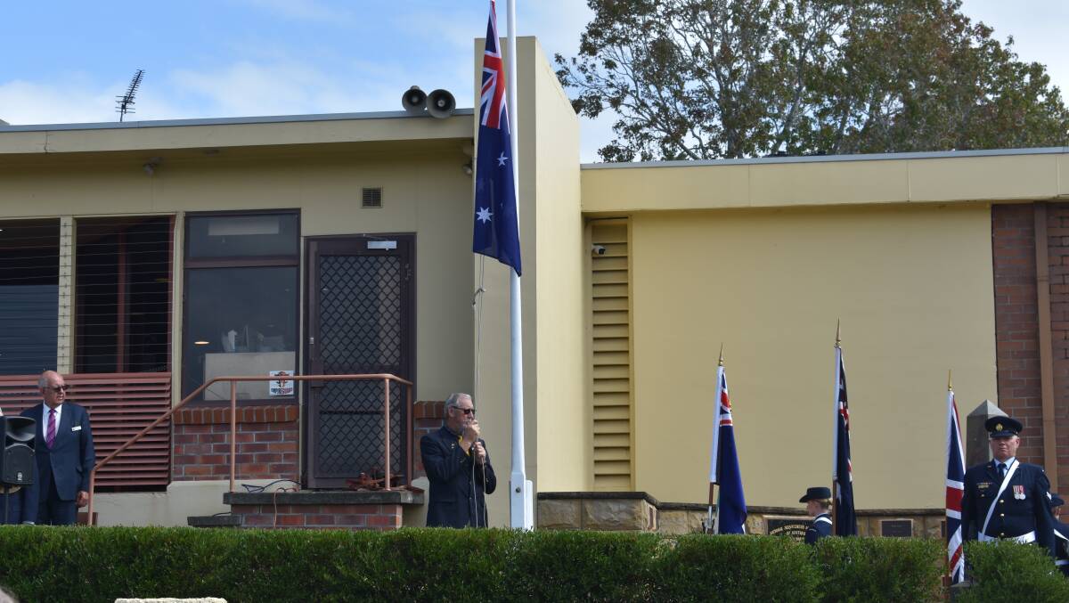Wayne Pritchard lowering the flag to half-mast. Picture by Angus Michie
