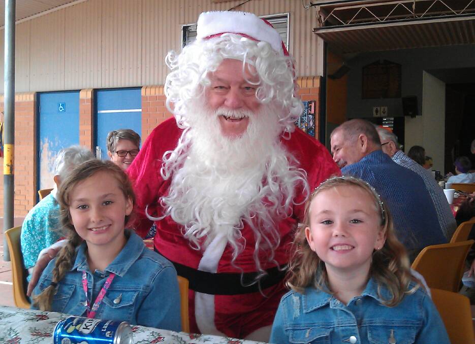 HAPPY: Santa made a special appearance at the luncheon much to the delight of these two little girls.