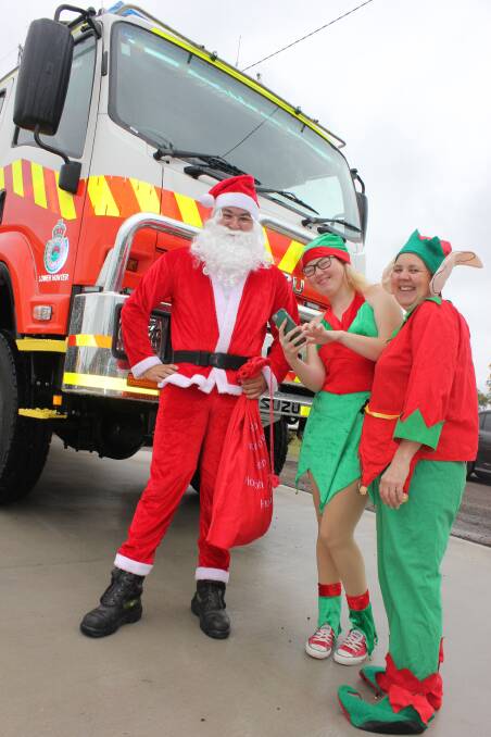 CHECKING THE NEW SANTA APP: Dungog Rural Fire Service members - Colvin Vogele, Ashleigh Thornton and Brigade Captain Heidi Thornton are ready for the annual lolly run and the new app for tracking Santa.