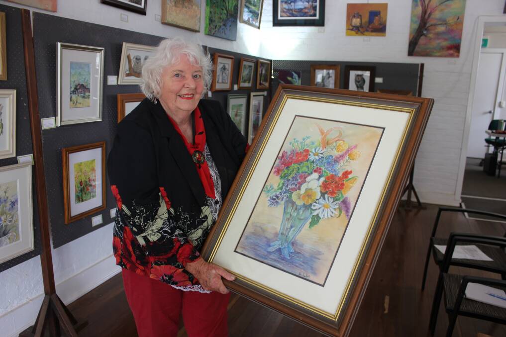 PRIZE: Dungog Arts Society publicity officer Joan Dawson with the raffle prize on offer - a work by Mavis Jukes.