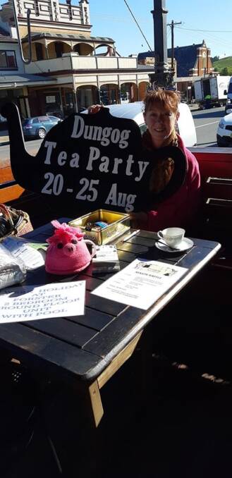 PLANNING: Erika Seck with one of the distinctive Dungog Tea Party signs the Dungog Men's Shed made for the event. They also have made the trophies.