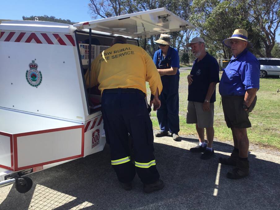 NEW EQUIPMENT: A representative of NSW Rural Fire Service Maitland discusses the new equipment with locals, Peter Haggarty, Nick Hellyer and Brian Pearce.