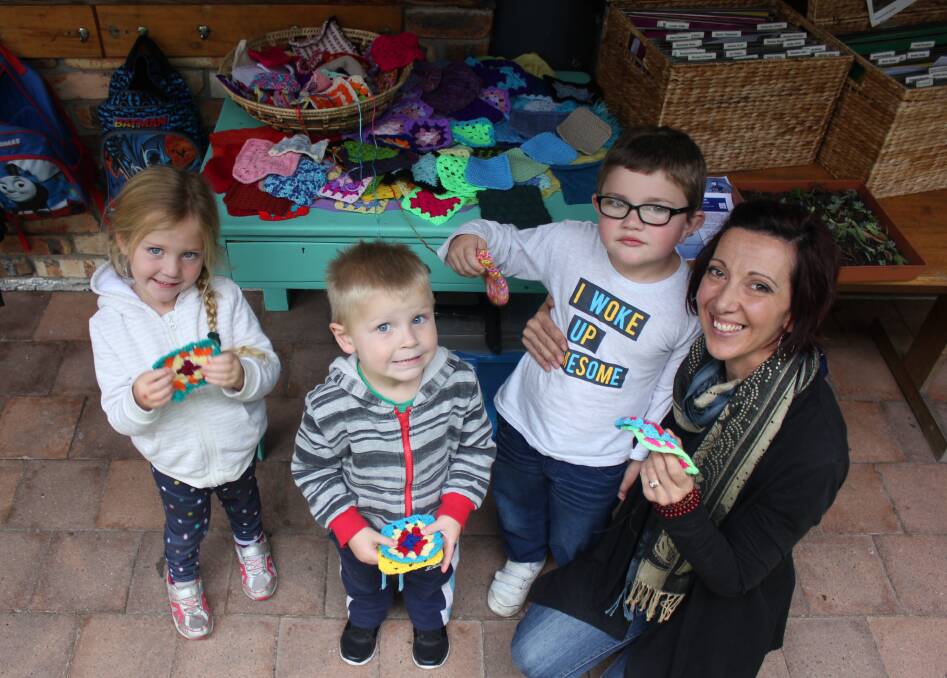 KNITTING FUN: Matilda Booth, Reuben Shaw, Rylan Hartfield and Sam Leggett with some of the beautiful crocheted and knitted squares.