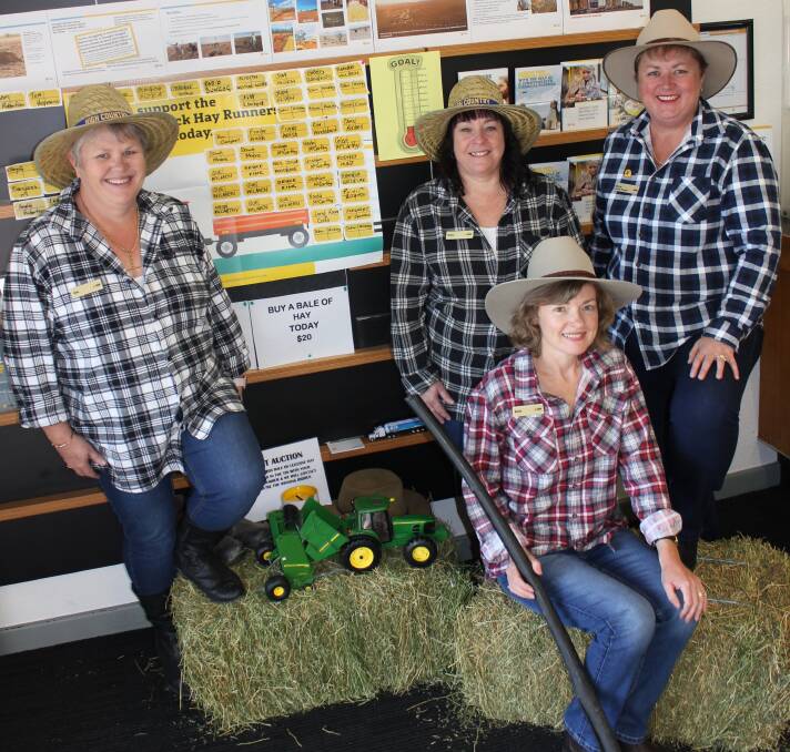 WEAR YOUR FLANNO FOR A FARMER: Sam Rumbel, Donna Skinner, Karen Hancock and Karen Nairne (front) with the donated bales up for silent auction and the wall of donations at the Commonwealth Bank's Dungog branch.