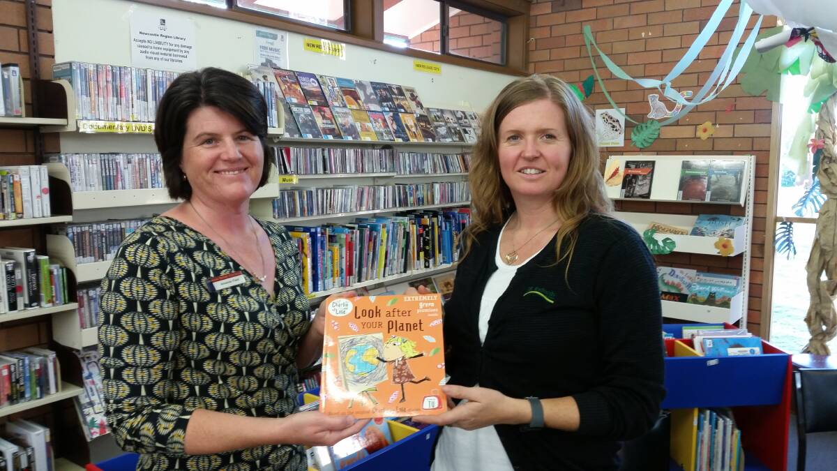 Dungog librarian Amanda Field accepts a new book from Megan Griffiths after her tea and talk sesion.