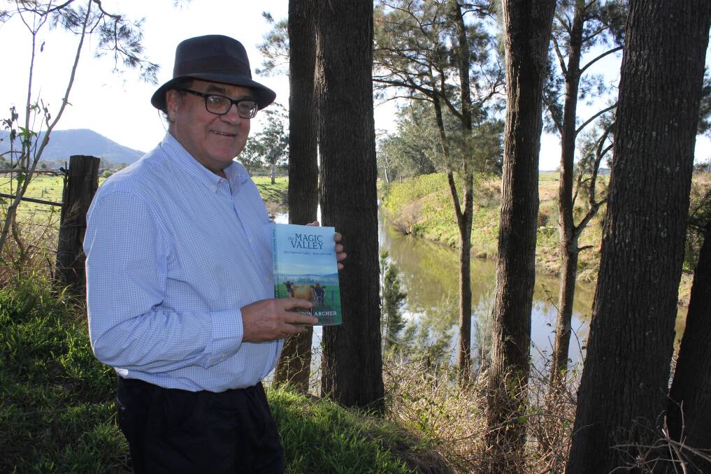 MAGIC: Cameron Archer on the riverbank at Paterson with his new book "The Magic Valley" which captures the changing patterns of the social and agricultural history of the valley. Picture: Michelle Mexon