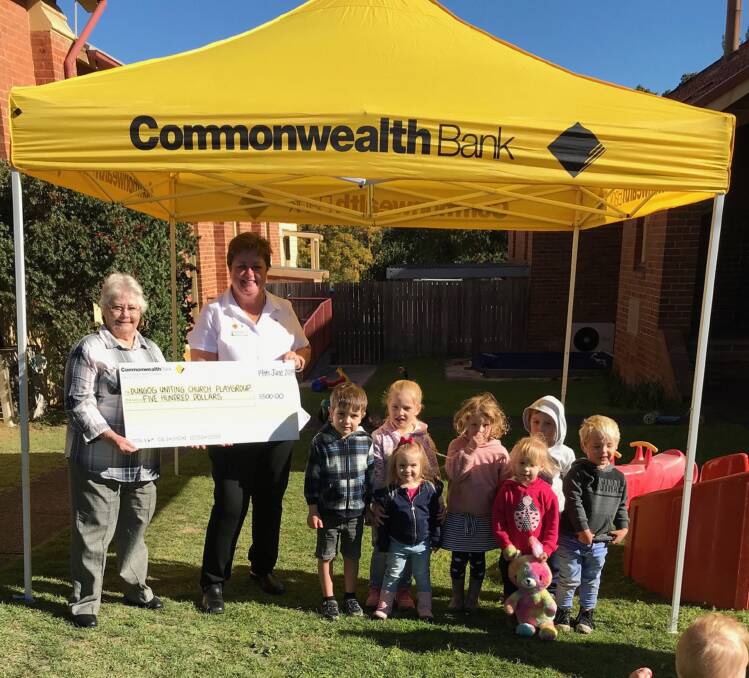 Donation: Pam Lawrence receives the cheque from Commonwealth Bank Dungog Branch Manager Karen Hancock much to the delight of the playgroup's little attendees.