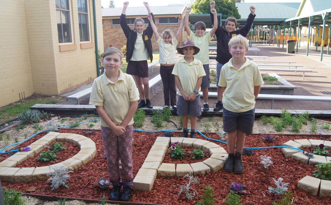 GARDENERS: Tahlie-Rose Stanley, Andrew Jenkins (front), Eli Middlebrook (centre) and (back row) Tameka Klein, Taya Digby, Aidan Howard and Dominik Schumacher with one of the gardens they look after.