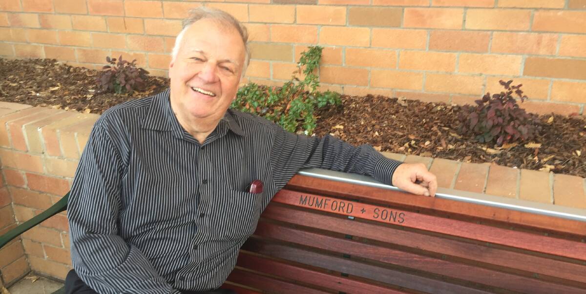 SON OF A GUN: Mayor Harold Johnston is seated on one of the new park benches, donated by Mumford & Sons, at the front of the council chambers.