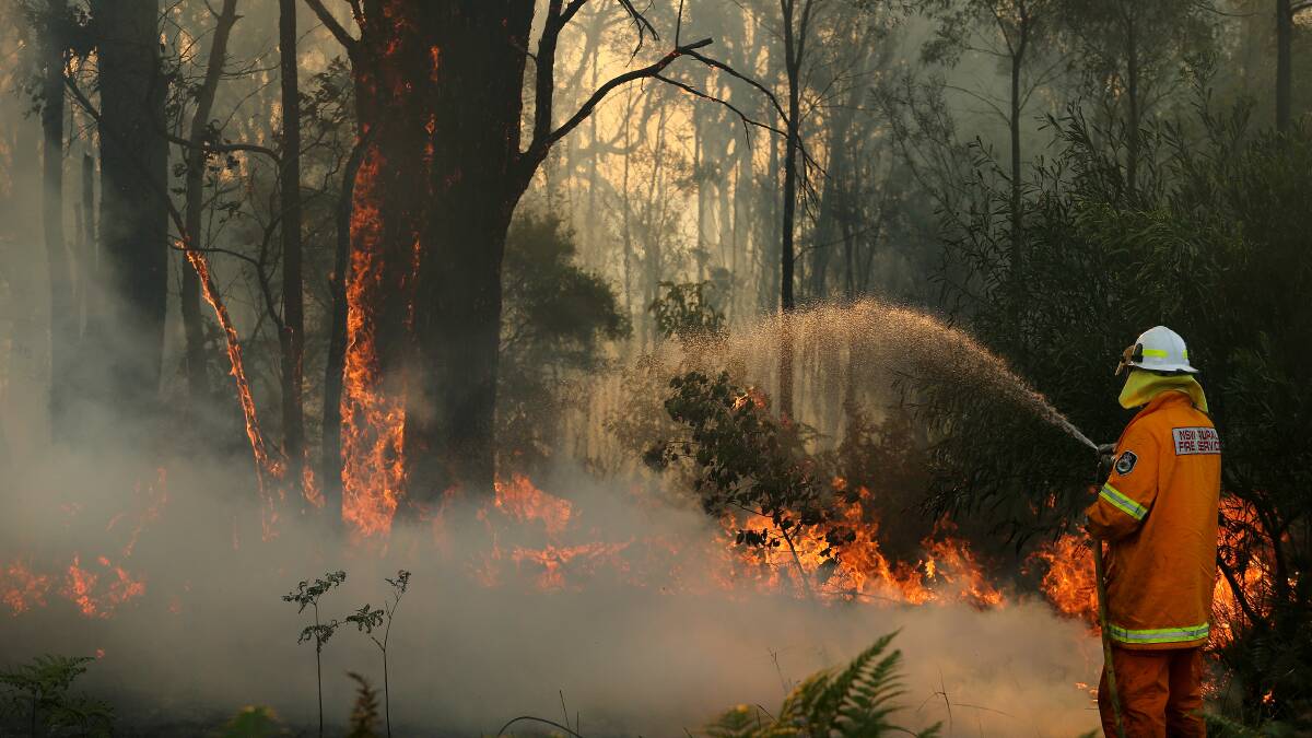 A firefighter battles the deliberately-lit Abermain blaze last month. The RFS is warning arsonists to think twice before lighting a fire. Picture: Marina Neil