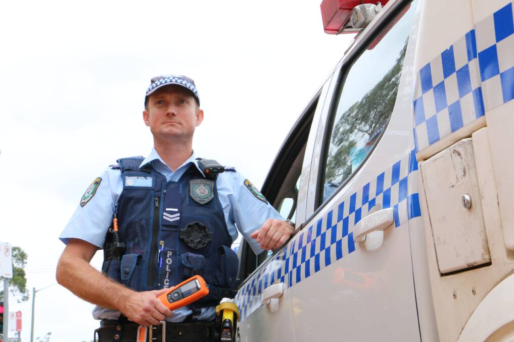 NSW Police Senior Constable Duncan Arnold with a breathalyser. Pictures: Ellie-Marie Watts