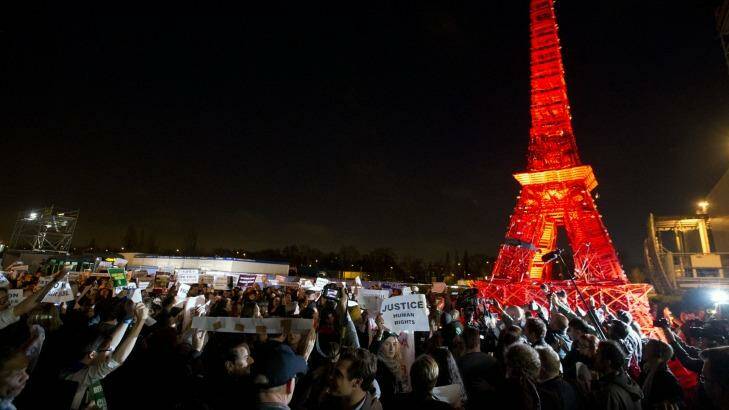 Activists gather next to a mini Eiffel Tower after a sit-in protest to denounce a draft text released at the climate conference.