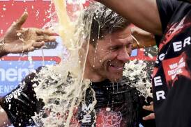Leverkusen coach Xabi Alonso is doused with beer by his players after their title win. (AP PHOTO)